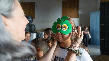 niña con máscara de flor